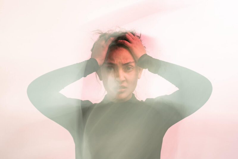 A woman holding her head as a result of anxiety
